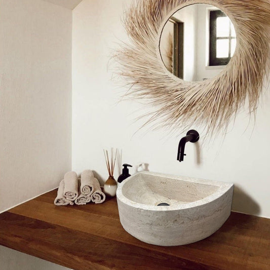 Troia Light Travertine Half Round Wall-mount Bathroom Sink (W)10" (L)16" (H)6" installed bathroom above wooden vanity and brown hand towels room scent